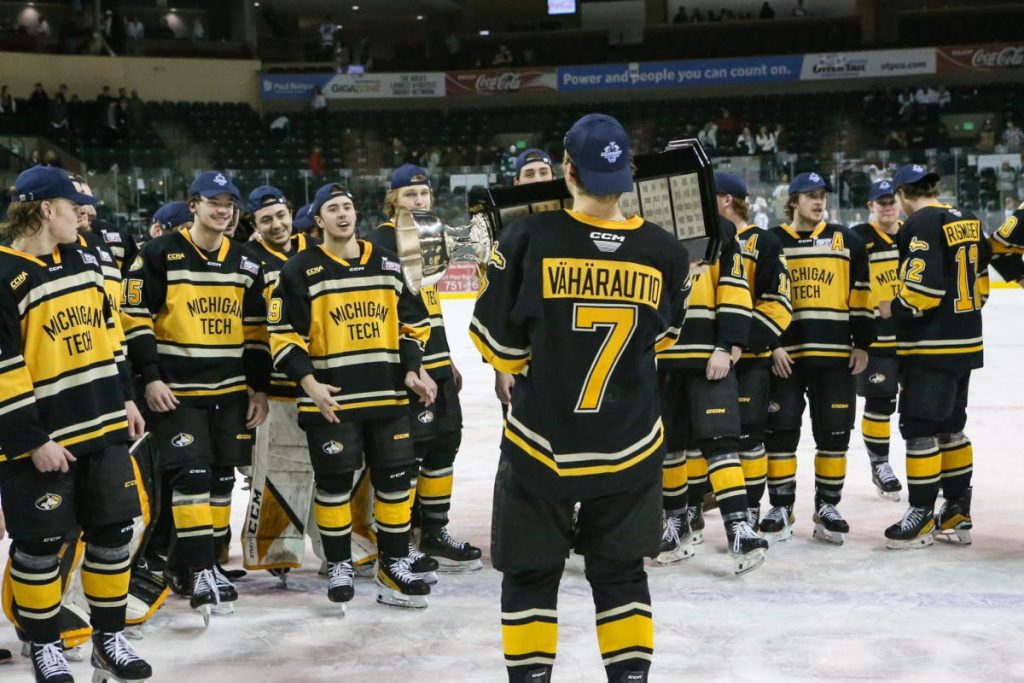 Michigan Techin jääkiekkojoukkue juhlii voittoa pokaalin kanssa.